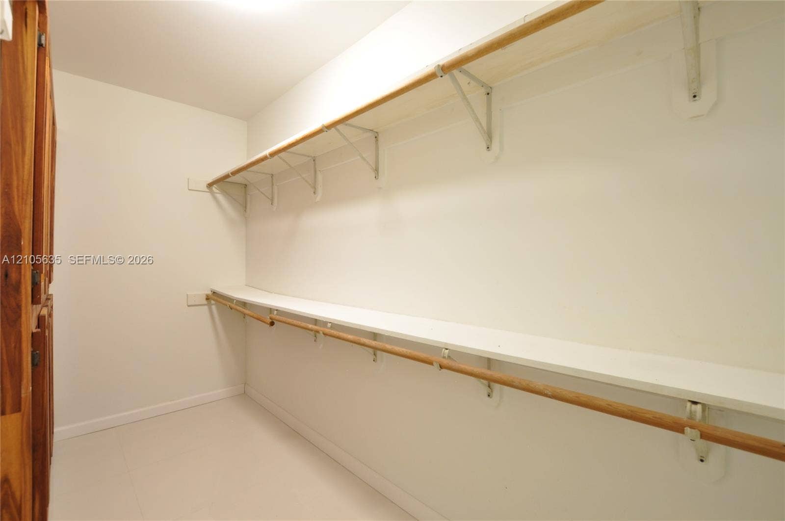 16760 SW 280th Street, Homestead, FL 33031 Storage space featuring tiered shelving, integrated wooden hanging rods, and neutral flooring