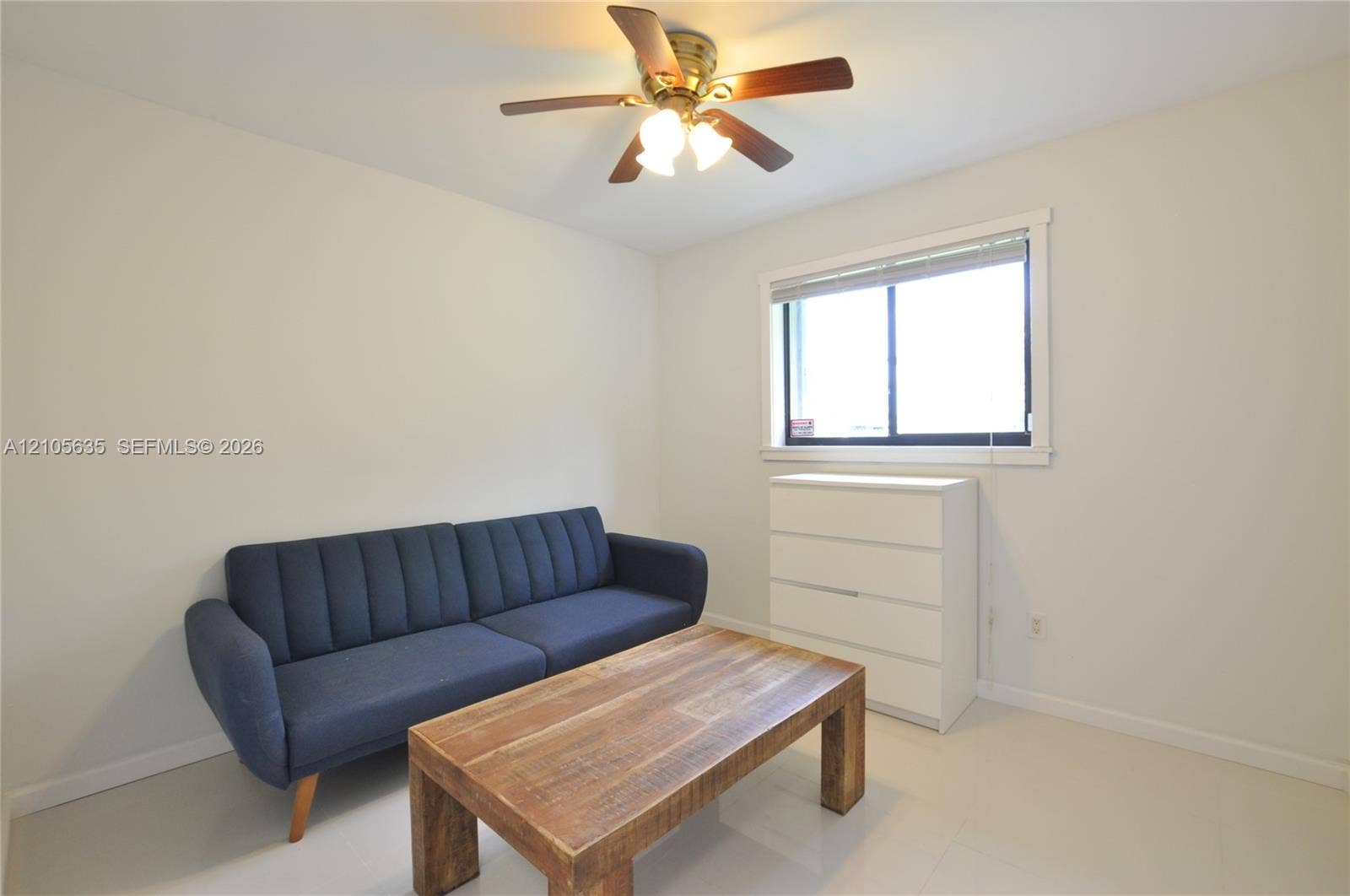 16760 SW 280th Street, Homestead, FL 33031 Neutral-toned interior featuring smooth-finish flooring, a sliding window with horizontal blinds, and a multi-light ceiling fan