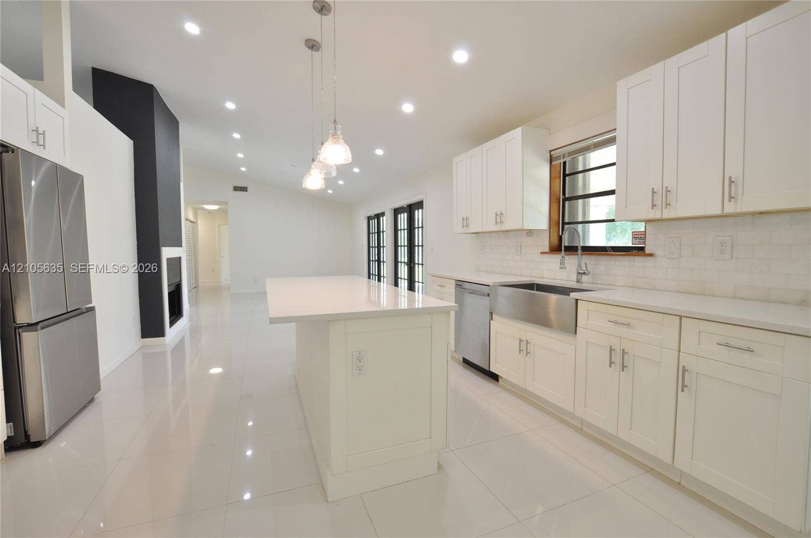 16760 SW 280th Street, Homestead, FL 33031 Kitchen featuring white shaker-style cabinetry, quartz countertops, a stainless steel apron-front sink, an island with pendant lighting, and polished tile flooring