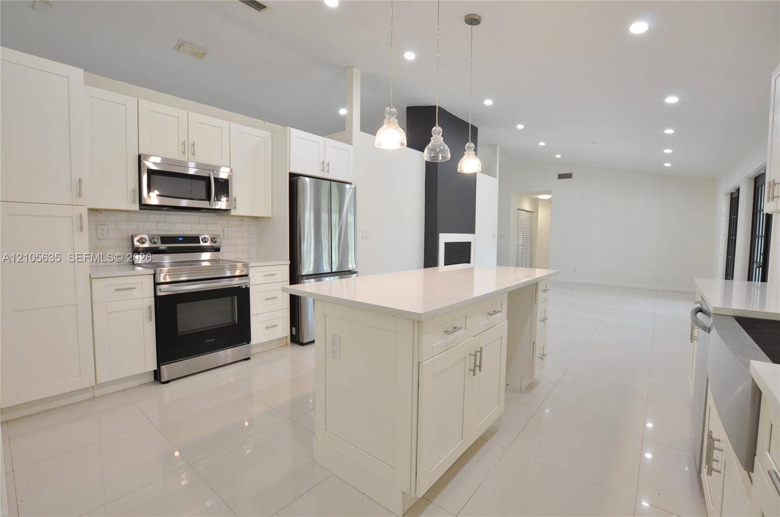 16760 SW 280th Street, Homestead, FL 33031 Kitchen featuring white shaker-style cabinetry, quartz countertops, stainless steel appliances, a central island, and recessed lighting