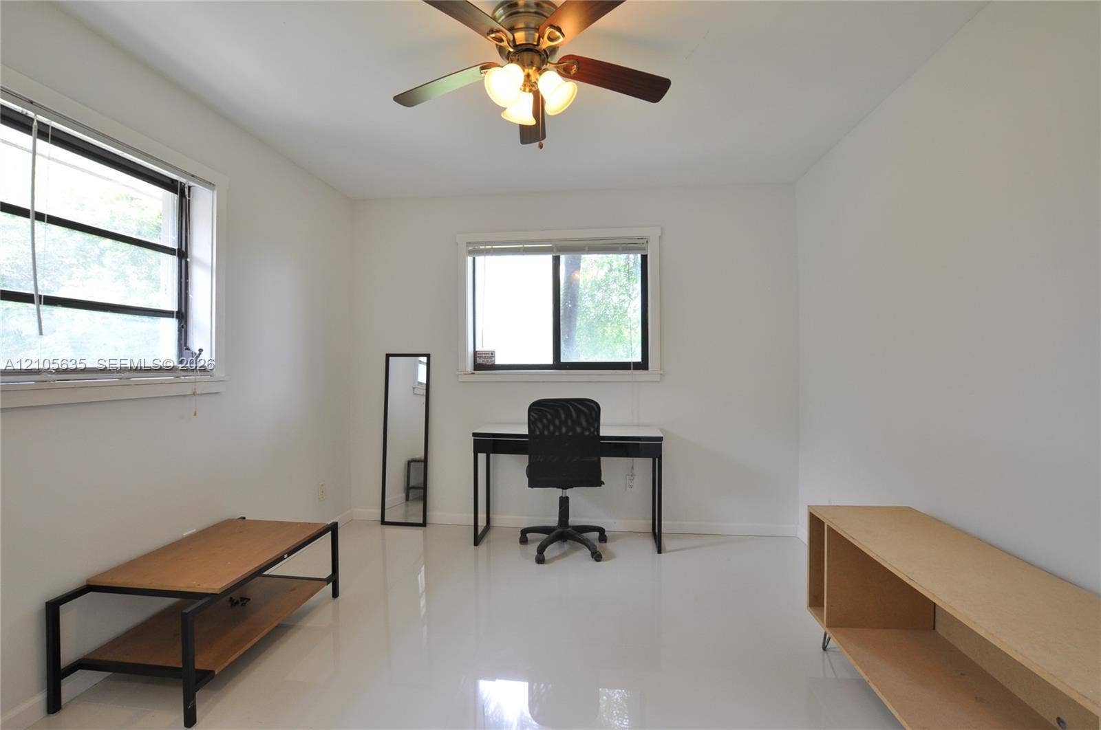 16760 SW 280th Street, Homestead, FL 33031 Interior room featuring neutral wall paint, polished finish flooring, dual sliding-sash windows, and a ceiling-mounted light fixture with a multi-blade fan