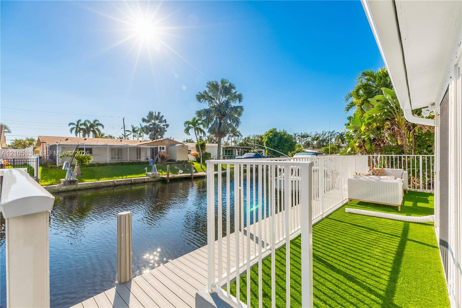 1429 NW 10th Street, #1, Dania, Dania Beach, FL 33004 Waterfront deck featuring a synthetic turf surface, a neutral-toned composite boardwalk, and perimeter white metal railing