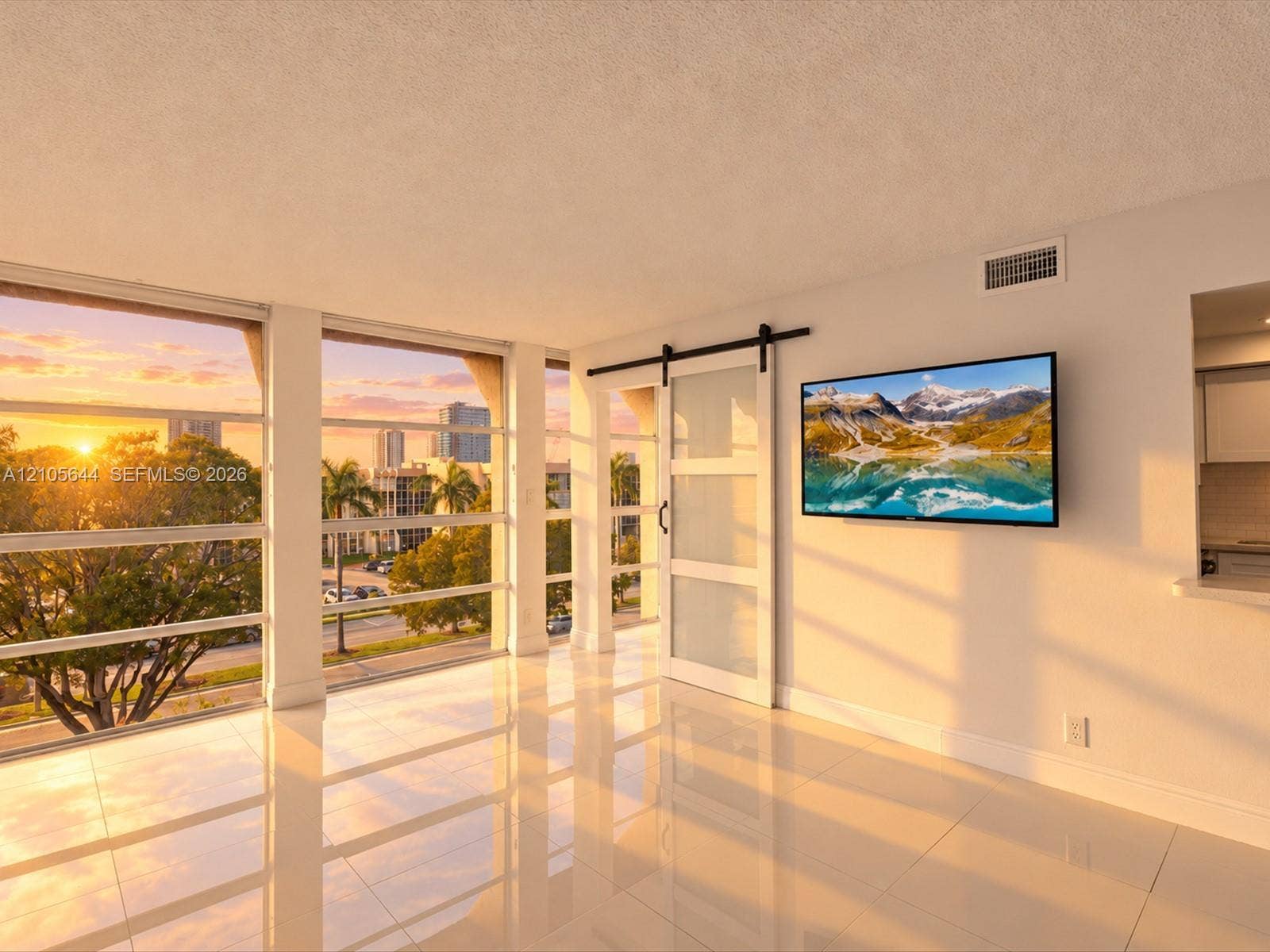2101 Atlantic Shores Boulevard, #502, Hallandale Beach, Hallandale Beach, FL 33009 Expansive floor-to-ceiling windows, polished tile flooring, frosted-glass barn-style sliding door with matte black hardware, and an urban backdrop