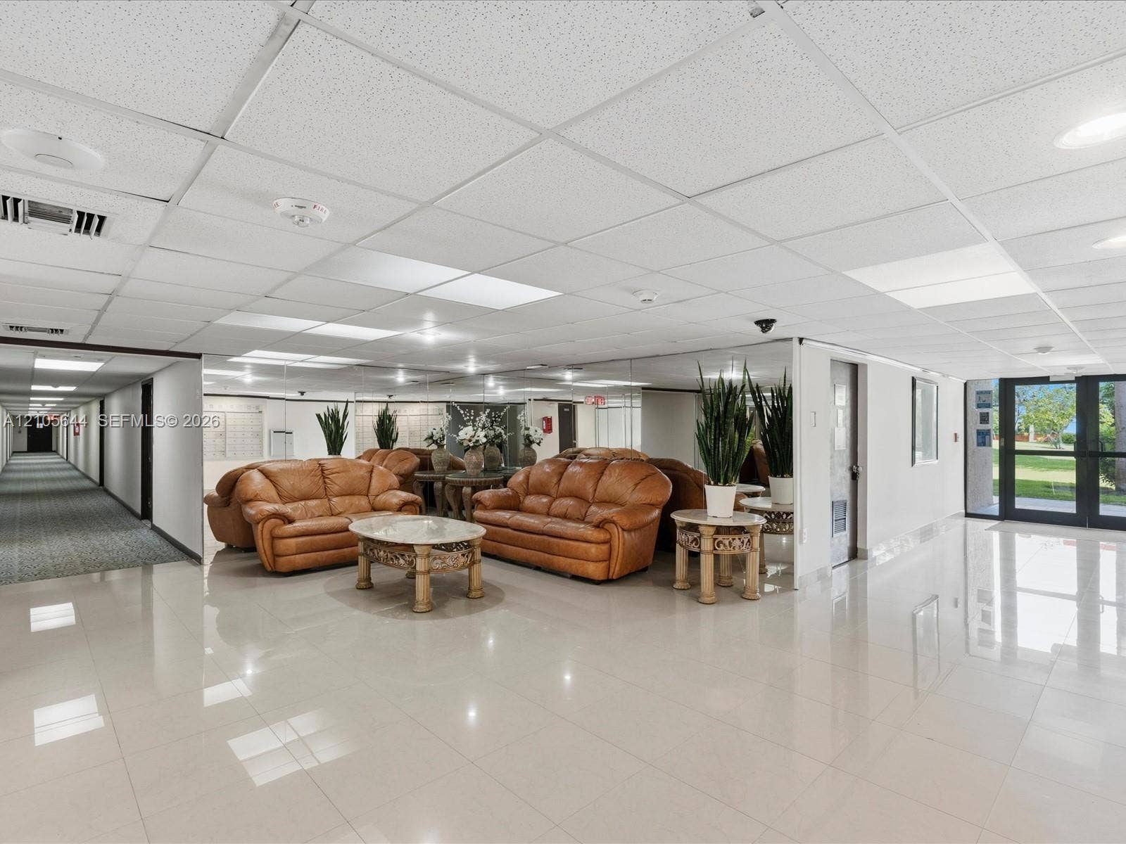 2101 Atlantic Shores Boulevard, #502, Hallandale Beach, Hallandale Beach, FL 33009 Common area featuring large-format ceramic tile flooring, a suspended acoustic tile ceiling with integrated recessed lighting, and expansive wall-to-wall mirrors