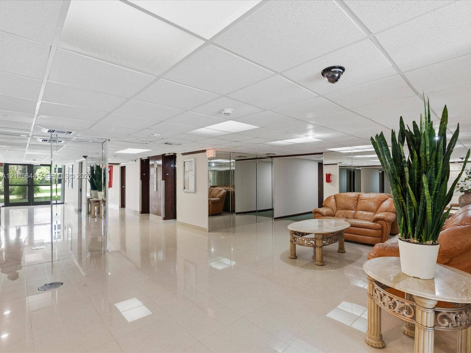 2101 Atlantic Shores Boulevard, #502, Hallandale Beach, Hallandale Beach, FL 33009 Polished tile flooring, suspended drop ceiling with recessed lighting, mirrored wall accents, and glass entry doors