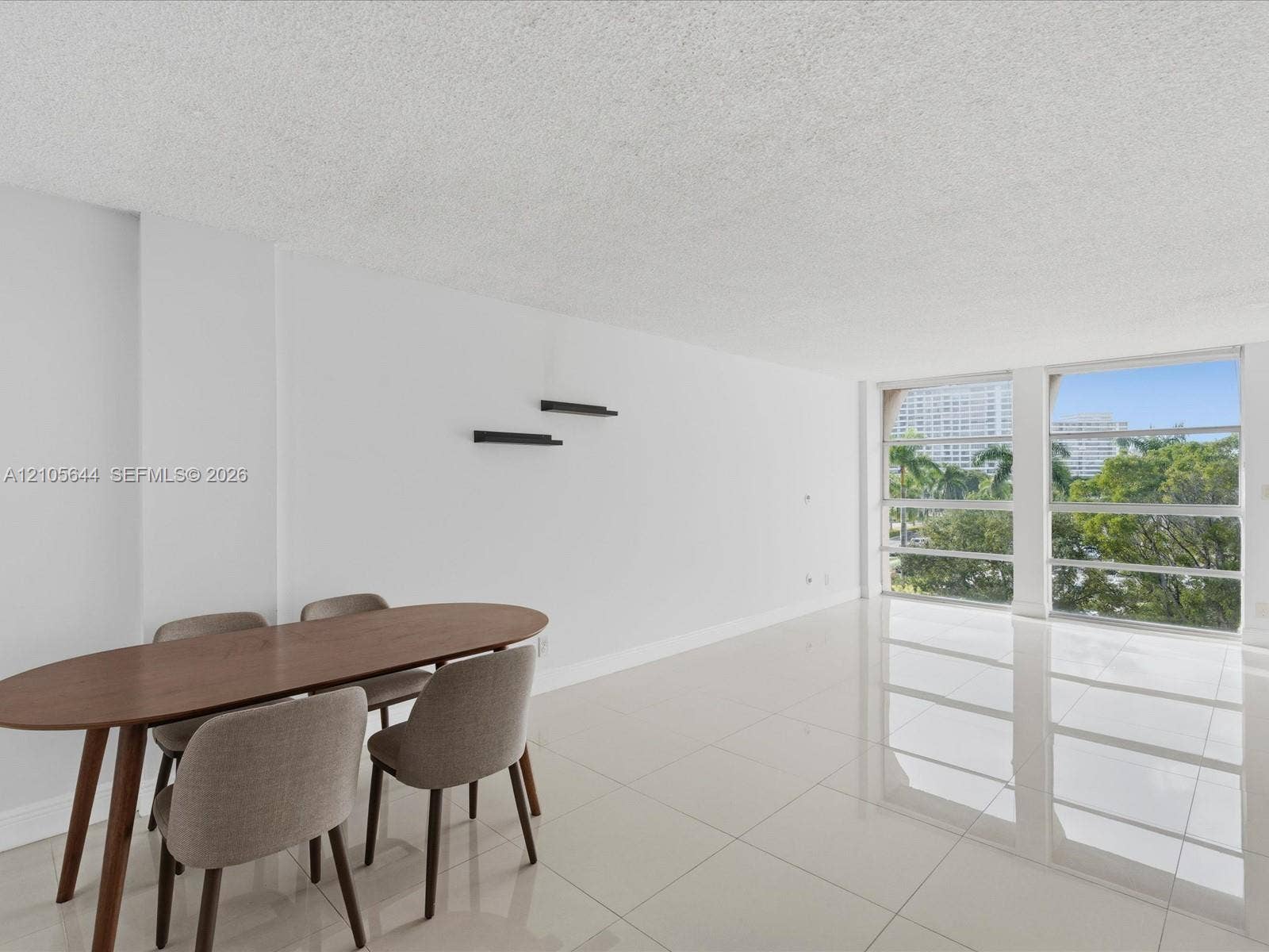 2101 Atlantic Shores Boulevard, #502, Hallandale Beach, Hallandale Beach, FL 33009 Open-concept living space featuring high-gloss tile flooring, floor-to-ceiling windows, and built-in wall shelving