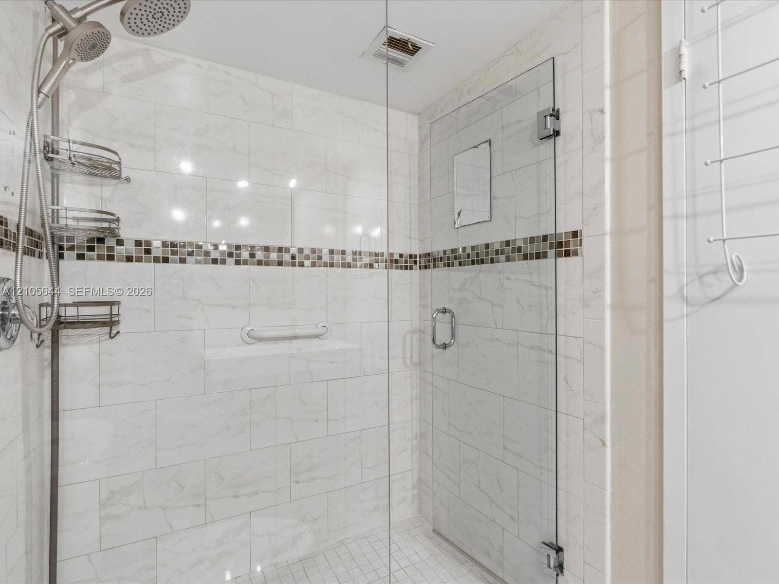 2101 Atlantic Shores Boulevard, #502, Hallandale Beach, Hallandale Beach, FL 33009 Walk-in shower featuring floor-to-ceiling large-format tile, mosaic accent band, glass panel enclosure, and handheld shower fixture