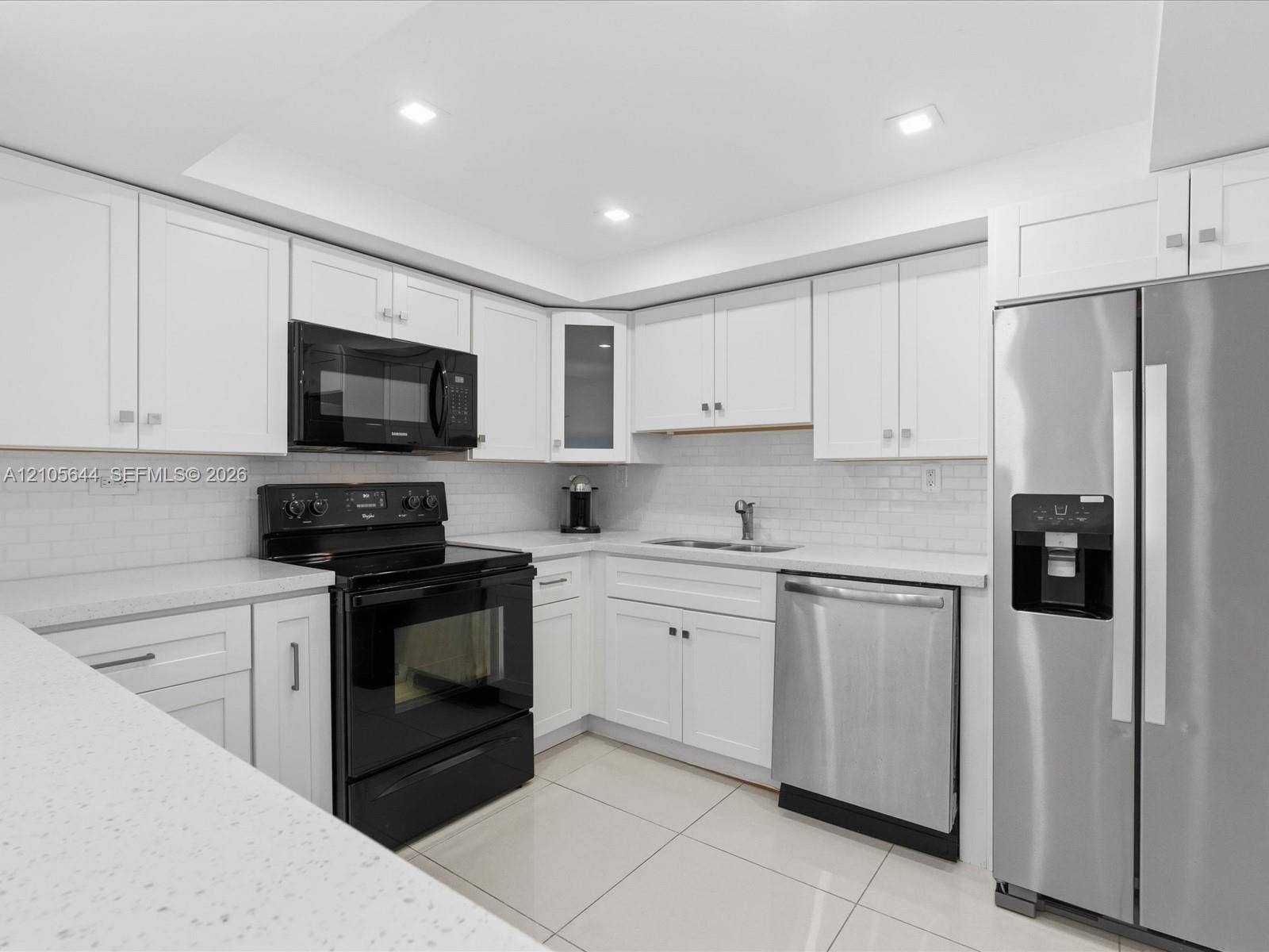 2101 Atlantic Shores Boulevard, #502, Hallandale Beach, Hallandale Beach, FL 33009 Kitchen featuring white shaker-style cabinetry, solid-surface countertops, a subway tile backsplash, recessed lighting, and stainless steel and black appliances