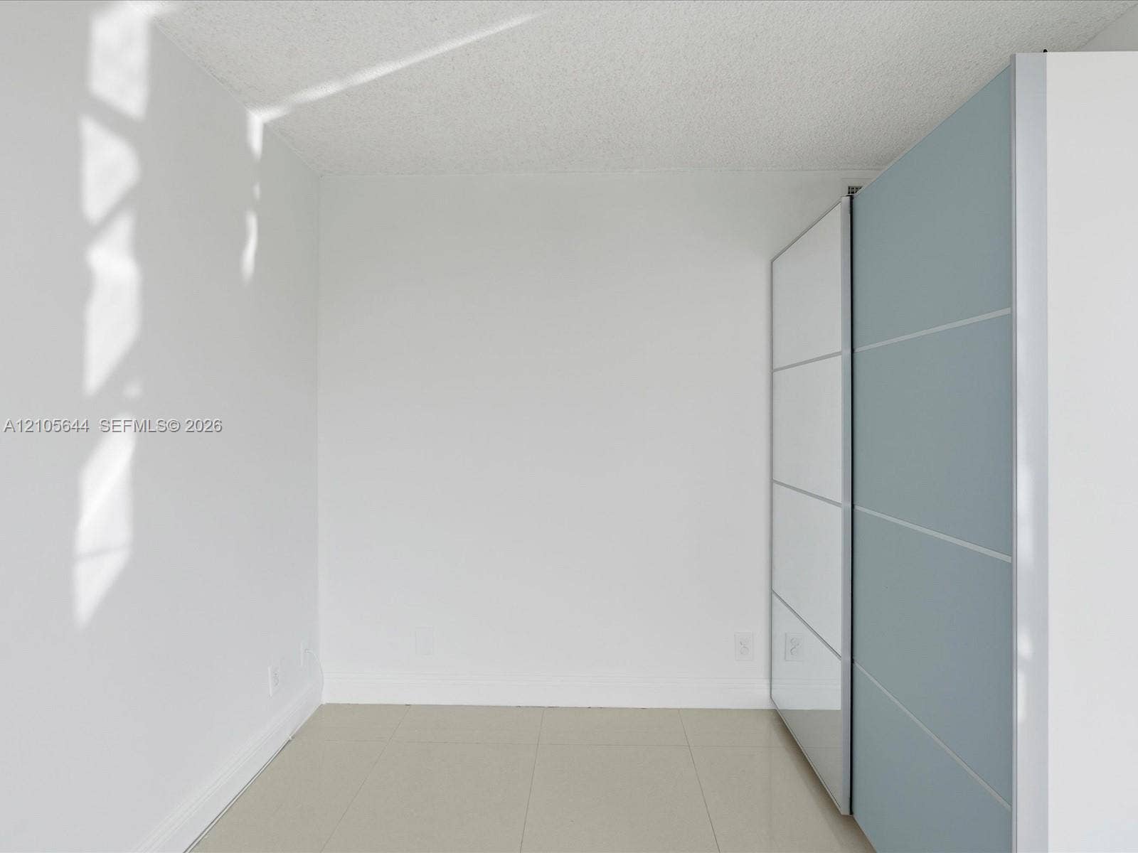 2101 Atlantic Shores Boulevard, #502, Hallandale Beach, Hallandale Beach, FL 33009 Built-in floor-to-ceiling cabinetry featuring high-gloss white and blue-grey paneling with metallic hardware, paired with neutral large-format tile flooring