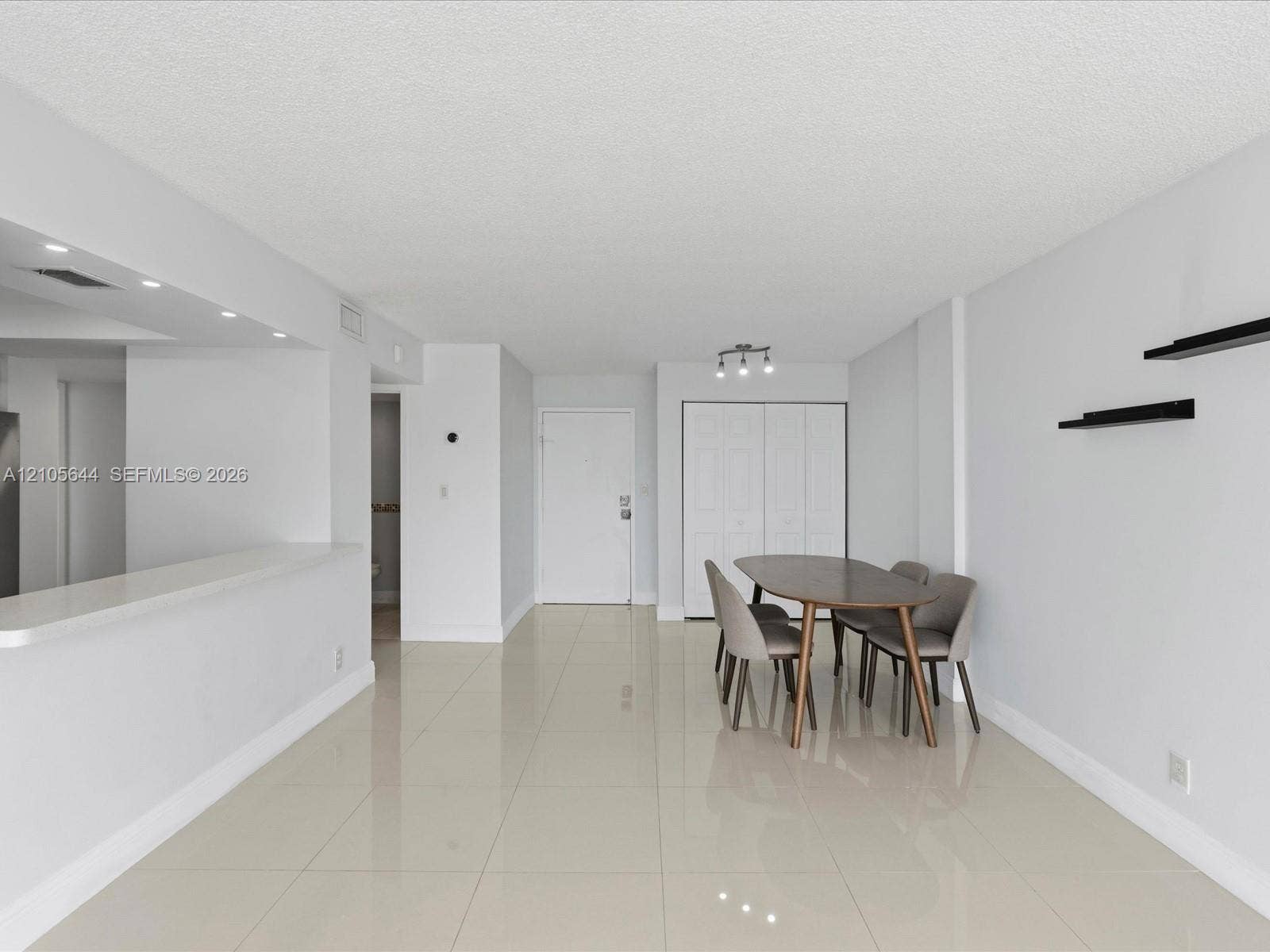 2101 Atlantic Shores Boulevard, #502, Hallandale Beach, Hallandale Beach, FL 33009 Large-format tile flooring, open-concept kitchen pass-through counter, ceiling-mounted track lighting, and built-in closet with paneled doors