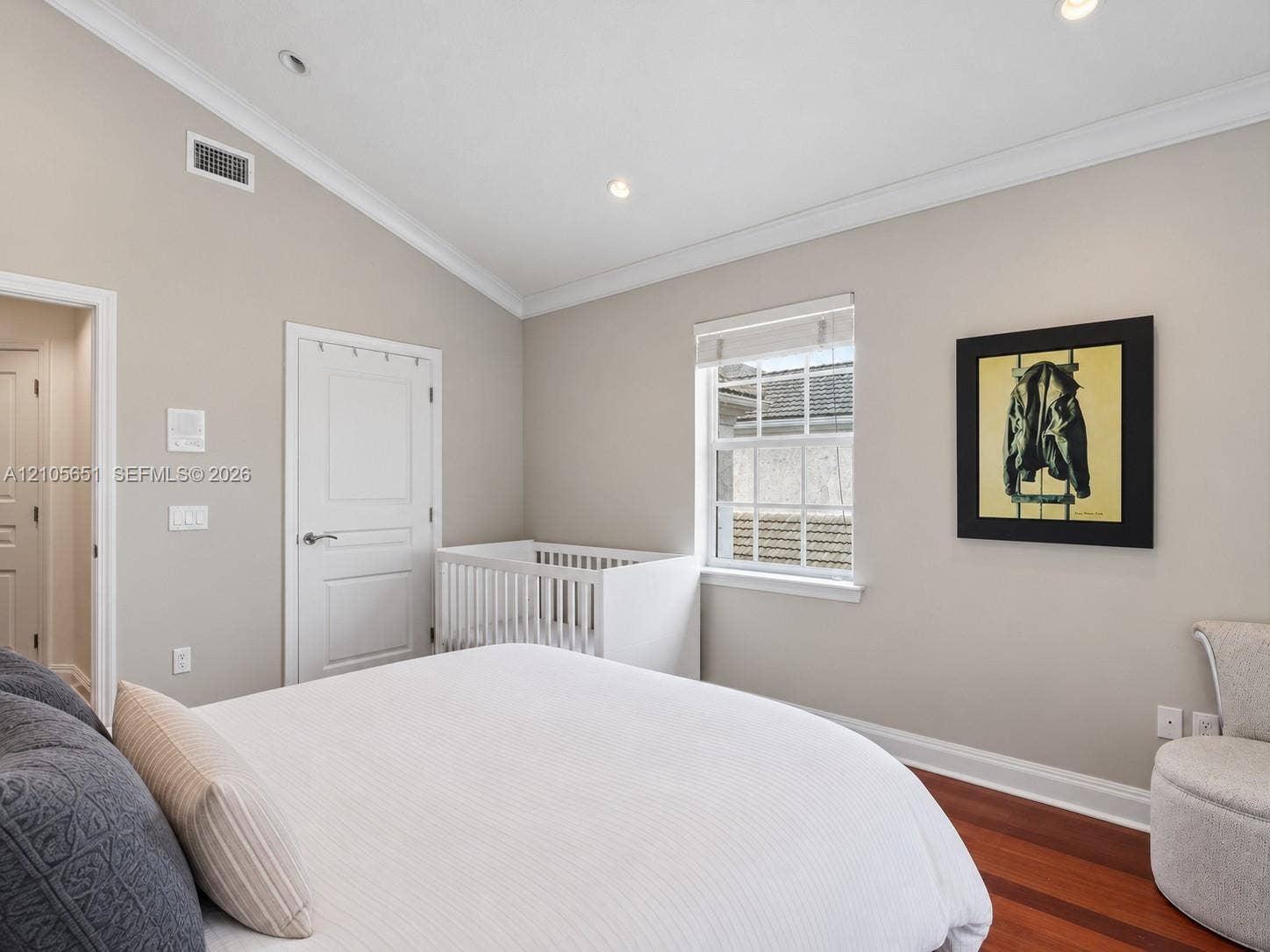 Vaulted ceiling with crown molding, wood-finish flooring, recessed lighting, and a single-hung window with custom-fit blinds