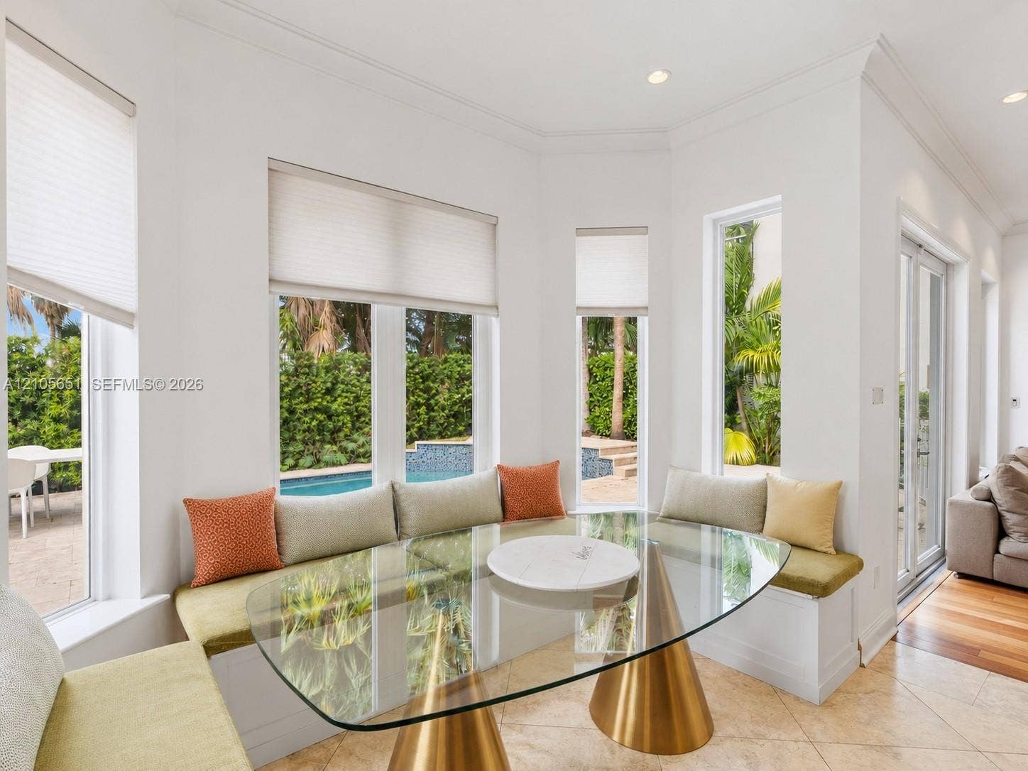 Bay window featuring built-in bench seating, recessed lighting, crown molding, and large-format tile flooring