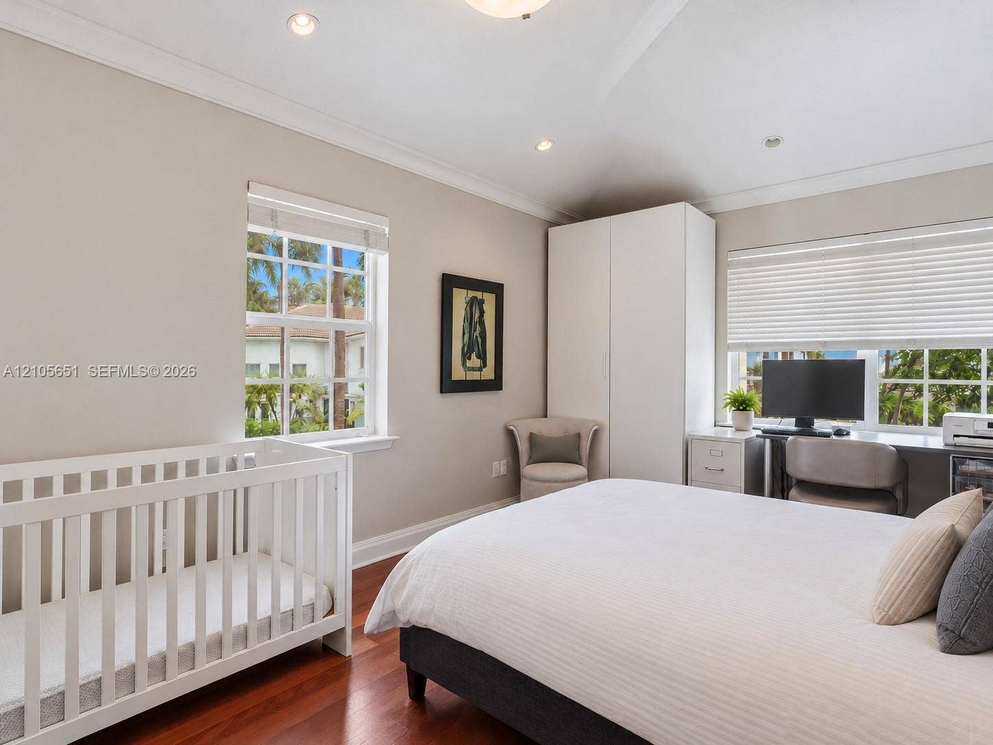Bedroom featuring wood-finish flooring, recessed lighting, crown molding, built-in storage cabinetry, and windows with integrated blinds