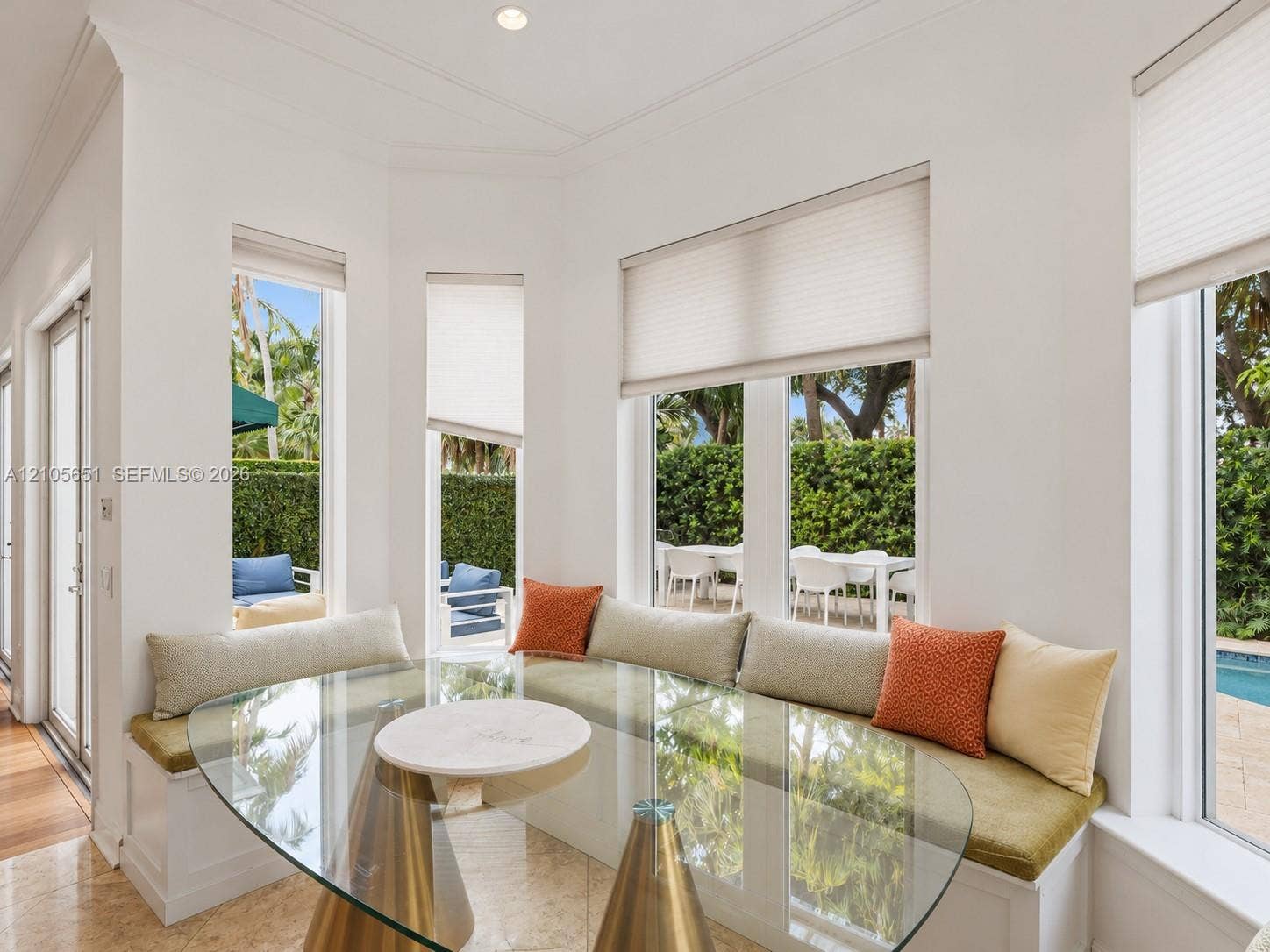 Built-in corner bench seating, expansive bay windows, crown molding, and stone-finish flooring