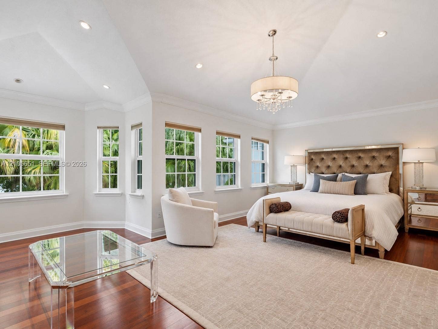 Vaulted ceilings with recessed lighting, wood-finish flooring, multi-pane windows, and a central drum chandelier