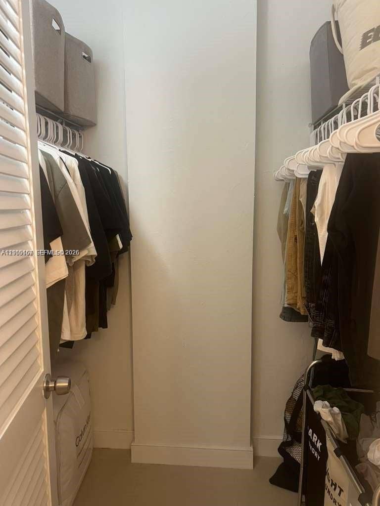 19380 Collins Avenue, #808, Sunny Isles Beach, FL 33160 Walk-in closet featuring built-in white wire shelving, overhead storage compartments, and a white louvered door