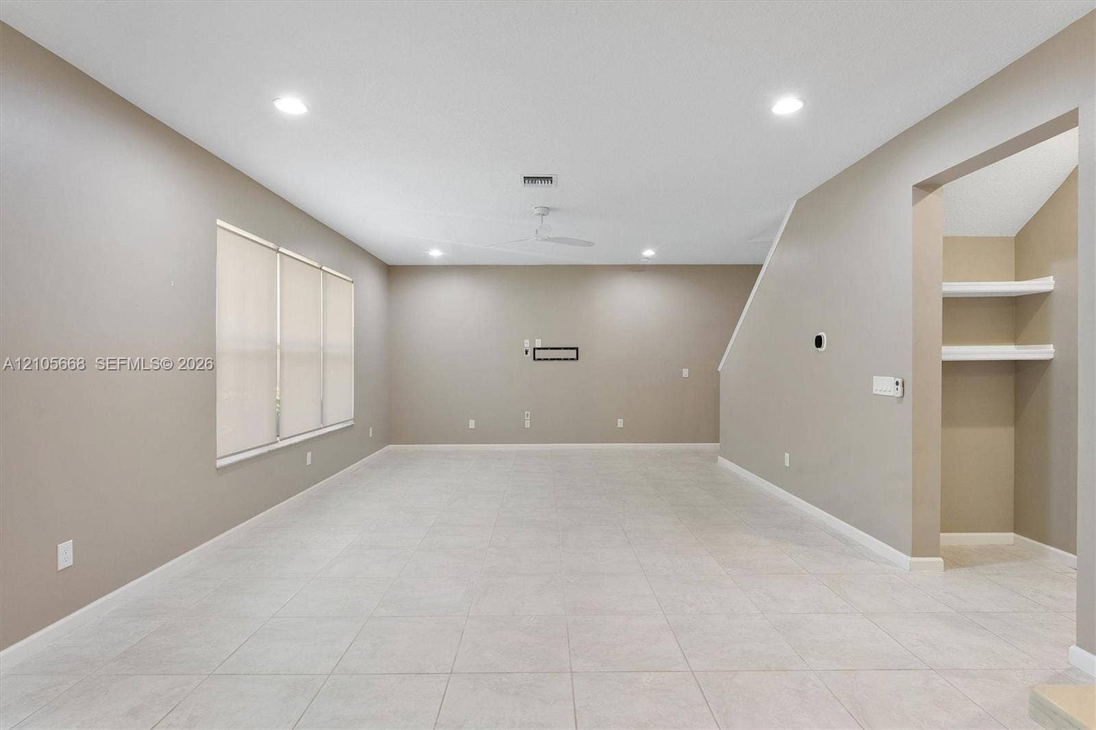 6307 Trails Of Foxford Court, West Palm Beach, FL 33415 Neutral-toned interior featuring oversized tile flooring, recessed lighting, a ceiling fan, and built-in shelving