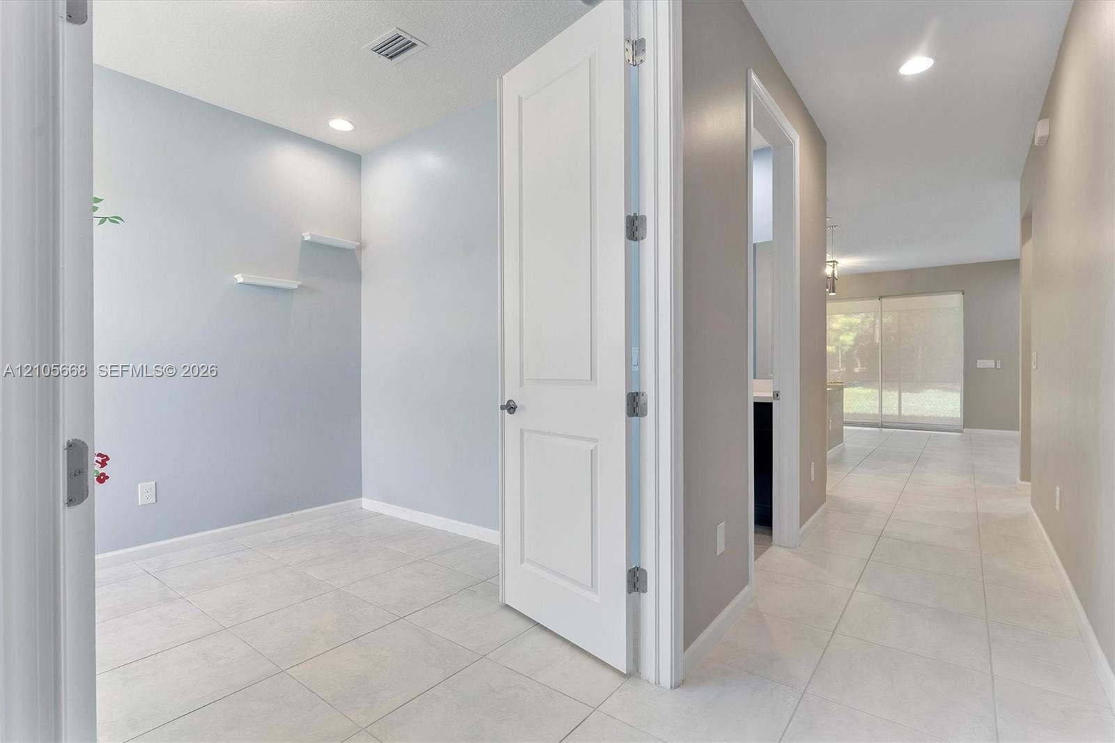 6307 Trails Of Foxford Court, West Palm Beach, FL 33415 Neutral-toned interior featuring large-format tile flooring, recessed lighting, and two built-in wall shelves