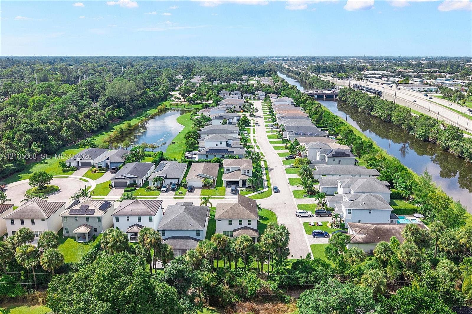 6307 Trails Of Foxford Court, West Palm Beach, FL 33415 Aerial perspective featuring a residential subdivision with paved roadways, suburban single-family housing, integrated retention ponds, and established perimeter vegetation