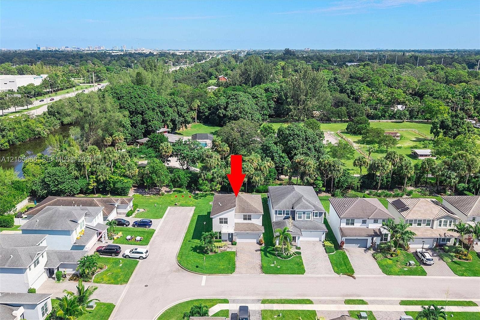 6307 Trails Of Foxford Court, West Palm Beach, FL 33415 Aerial view of a residential property featuring a multi-story home with an attached garage, manicured landscaping with mature trees, and a circular driveway