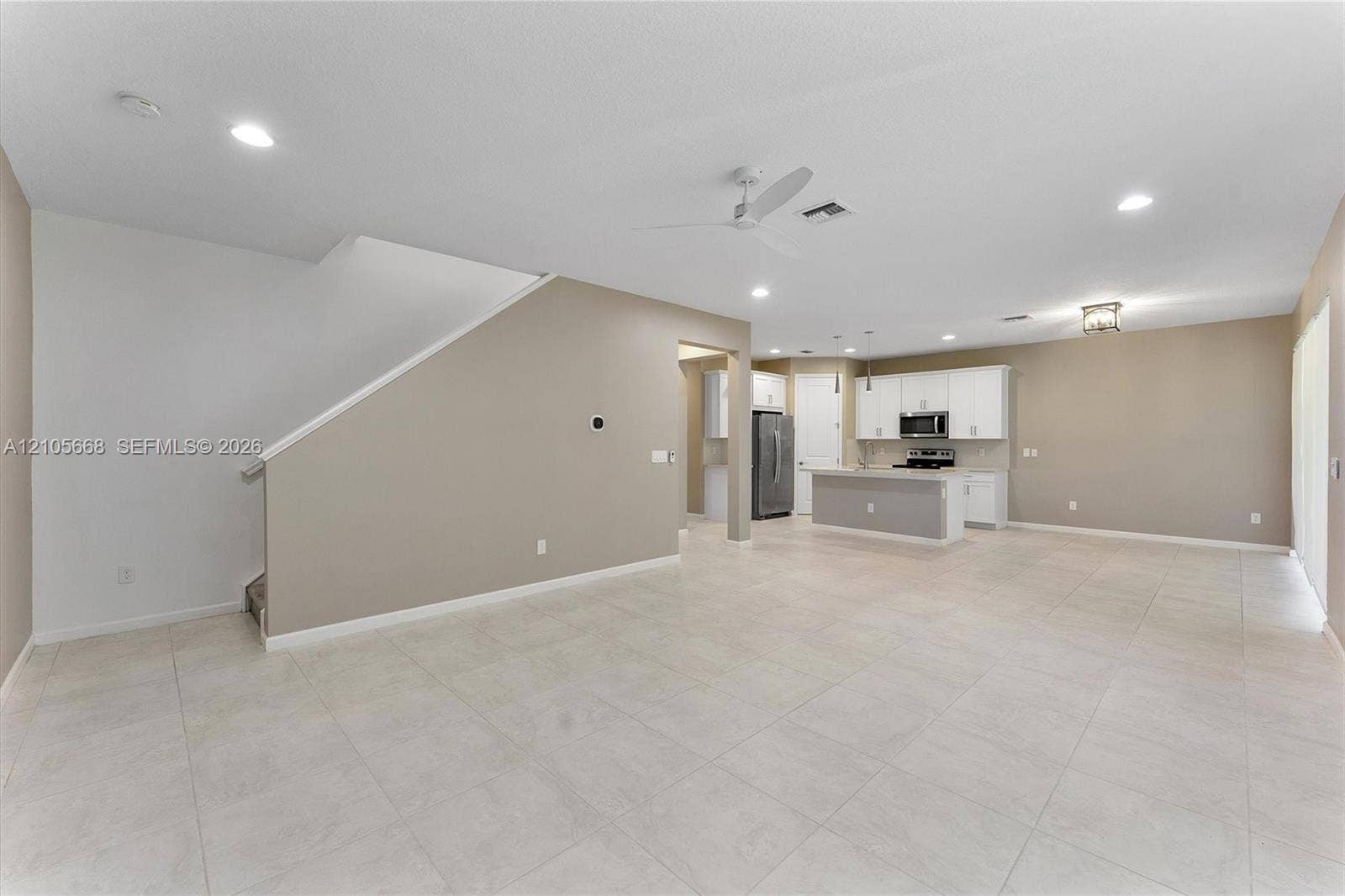 6307 Trails Of Foxford Court, West Palm Beach, FL 33415 Open-concept floor plan featuring tile flooring, recessed lighting, ceiling fan, and a kitchen with white cabinetry and a center island