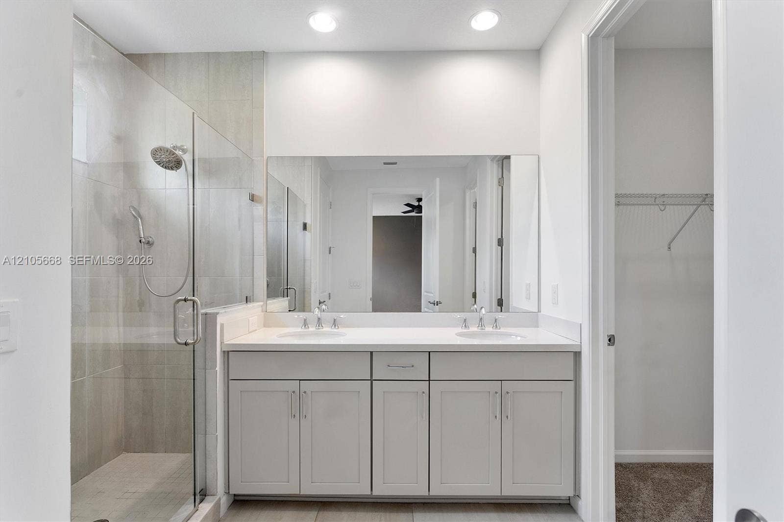 6307 Trails Of Foxford Court, West Palm Beach, FL 33415 Dual-sink vanity with light-tone cabinetry and white countertop, walk-in shower with glass enclosure, and recessed lighting