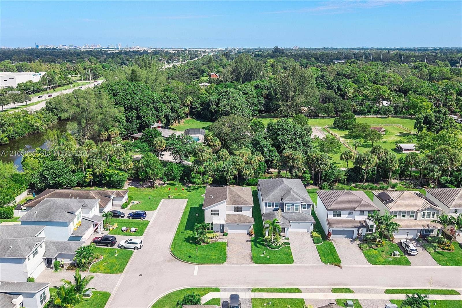 6307 Trails Of Foxford Court, West Palm Beach, FL 33415 Aerial perspective of a suburban neighborhood featuring multi-story dwellings, paver driveways, attached garages, and extensive mature tree canopy