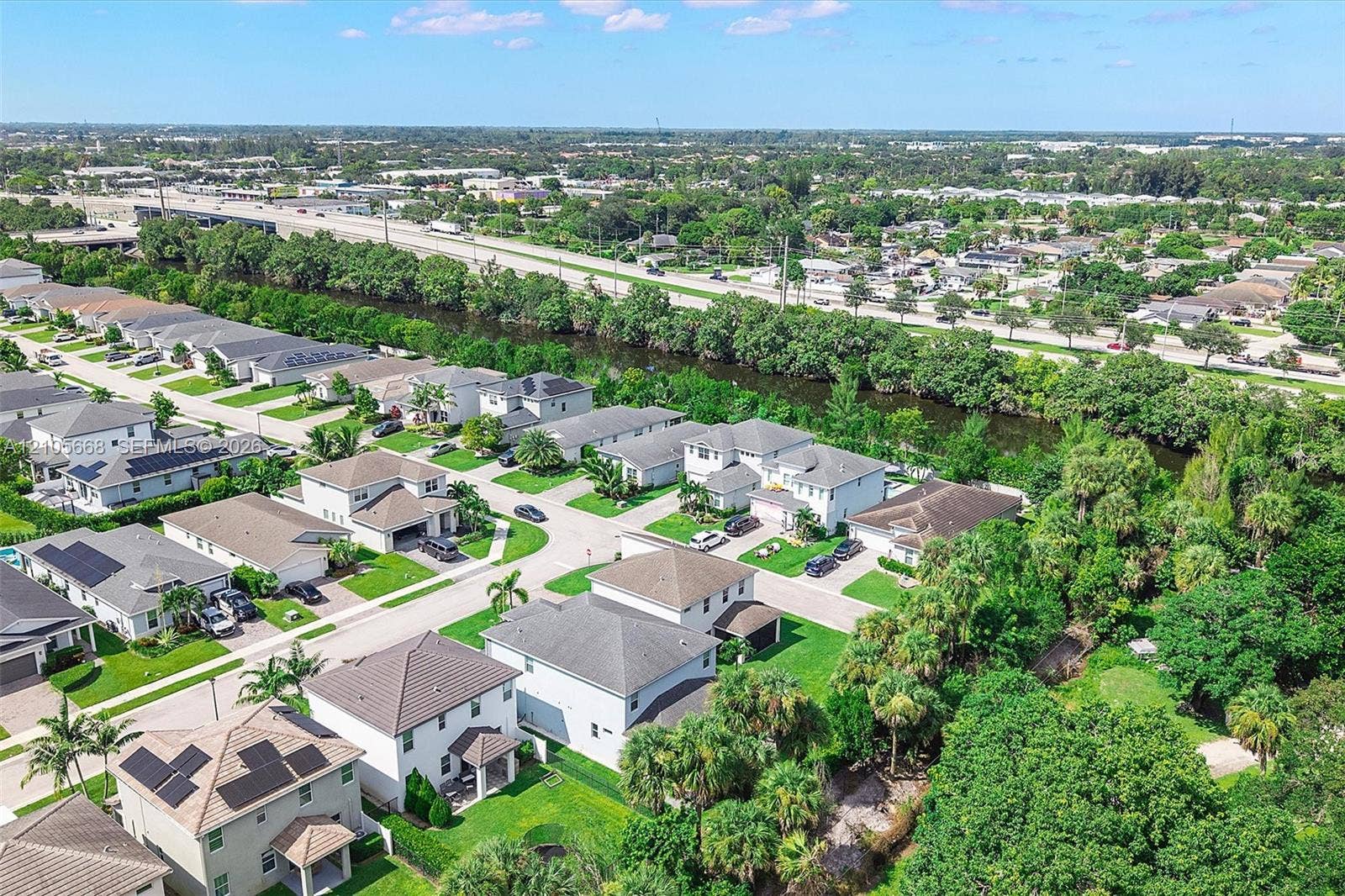6307 Trails Of Foxford Court, West Palm Beach, FL 33415 Aerial perspective of a suburban neighborhood featuring concrete tile roofing, solar panel arrays, manicured lawns, and perimeter landscaping