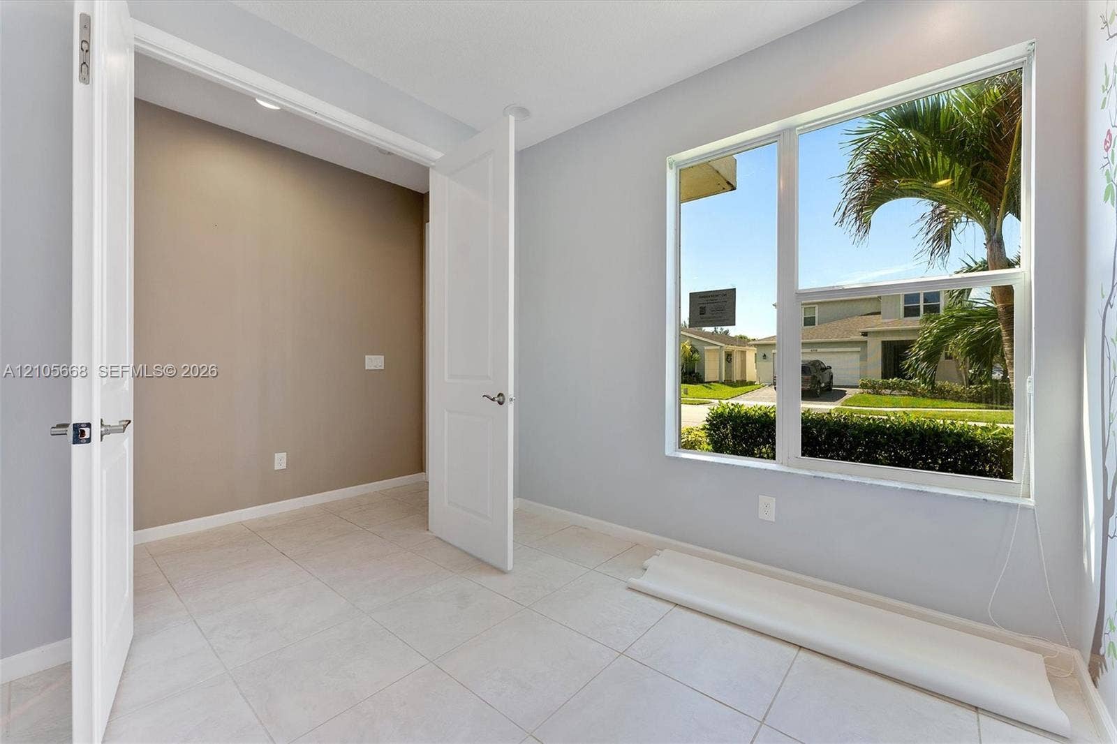 6307 Trails Of Foxford Court, West Palm Beach, FL 33415 Light-filled room featuring large-format tile flooring, neutral wall tones, multi-panel interior doors, and a picture window