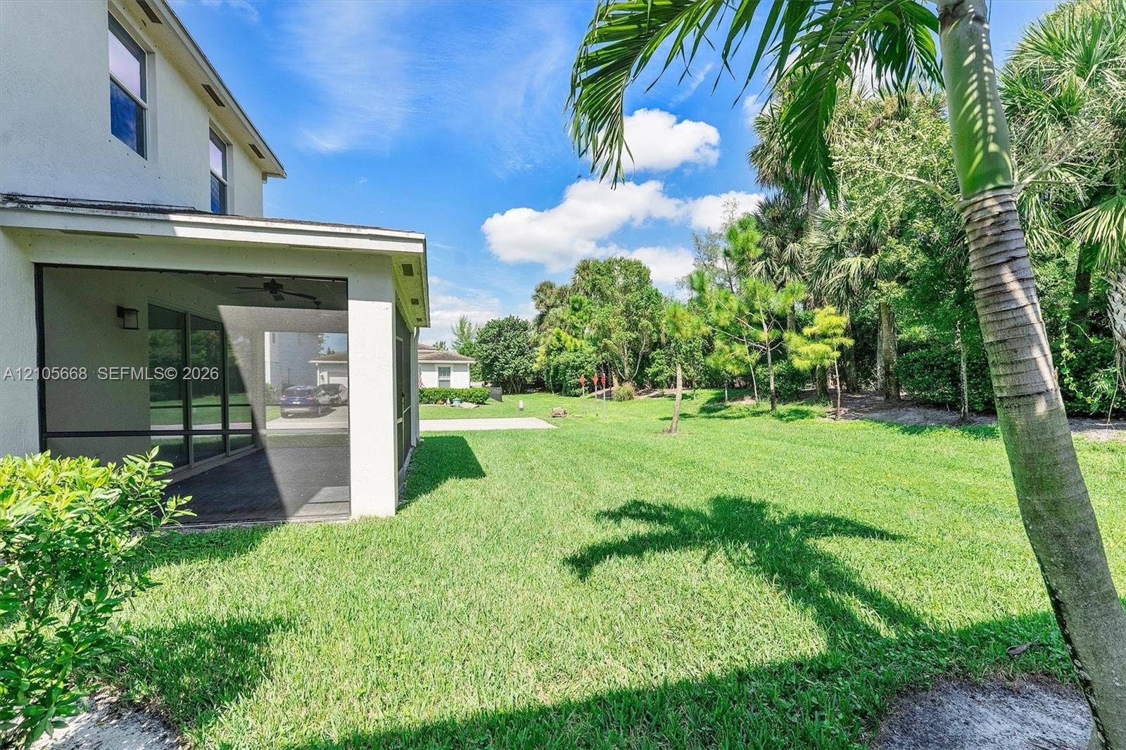 6307 Trails Of Foxford Court, West Palm Beach, FL 33415 Screened-in patio with concrete flooring, stucco exterior, expansive lawn, and mature landscaping