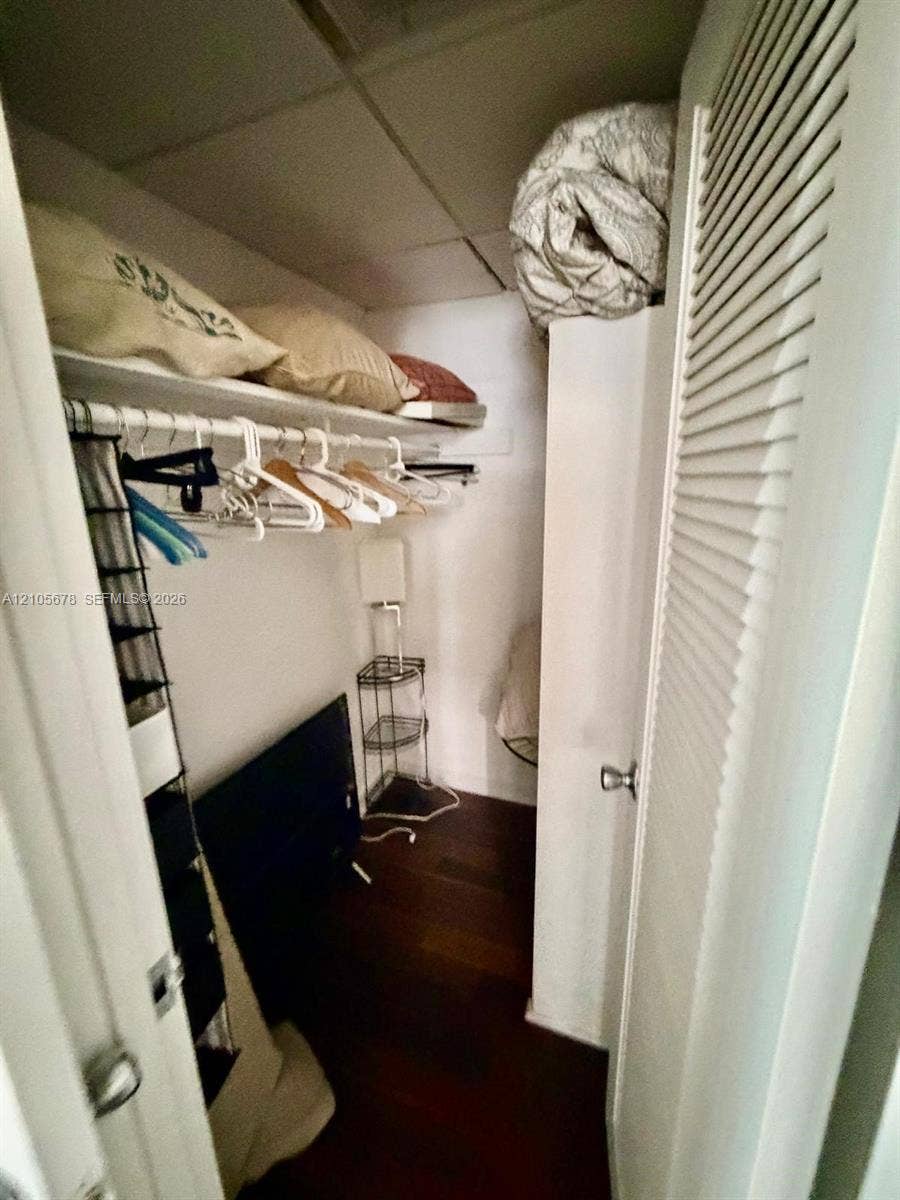 4001 S Ocean Drive, #14F, Hollywood, FL 33019 Storage closet featuring wood-finish flooring, a built-in shelf, and a louvered closet door
