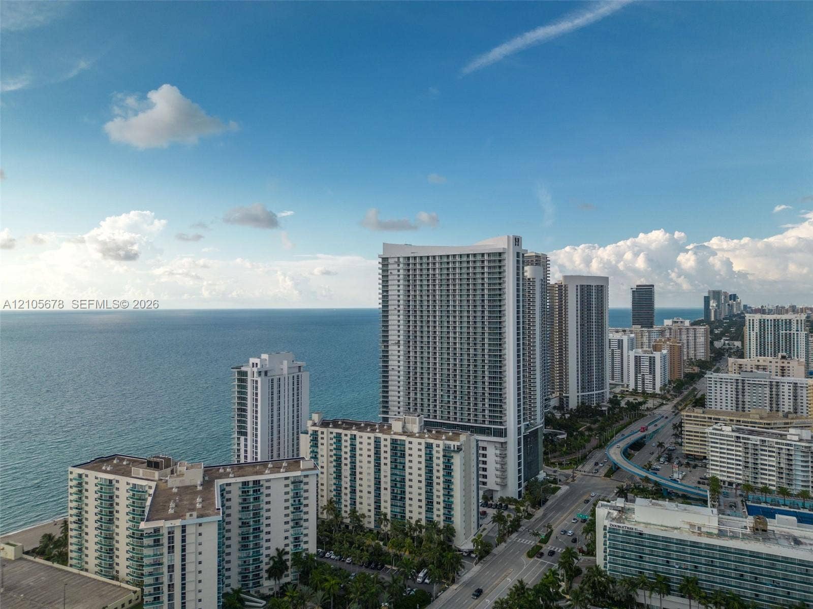4001 S Ocean Drive, #14F, Hollywood, FL 33019 Aerial perspective of coastal high-rise architecture featuring glass-railed private balconies, prominent oceanfront positioning, and proximity to expansive shoreline