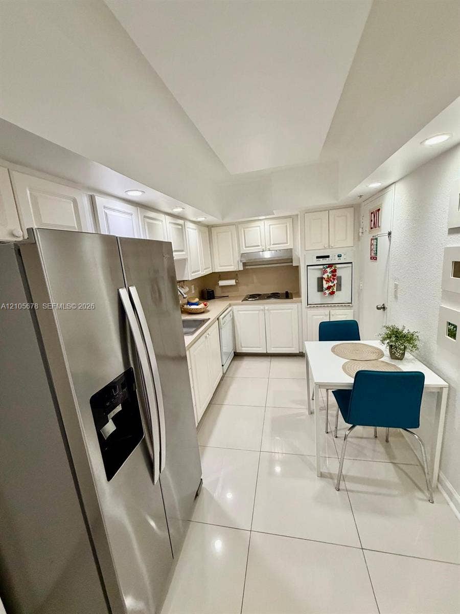 4001 S Ocean Drive, #14F, Hollywood, FL 33019 Kitchen featuring white cabinetry, stainless steel side-by-side refrigerator, built-in wall oven, recessed lighting, and large-format tile flooring