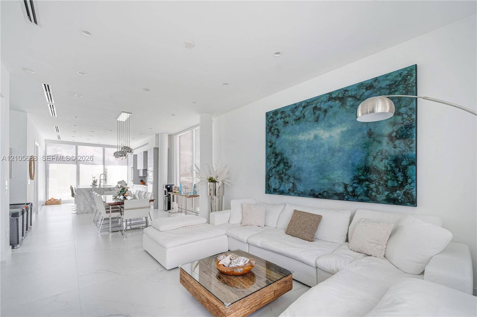 164 W Avenue C, Key Largo, FL 33037 Open-concept interior featuring large-format porcelain tile flooring, recessed ceiling lighting, floor-to-ceiling windows, and a central kitchen island with a stone-finish countertop