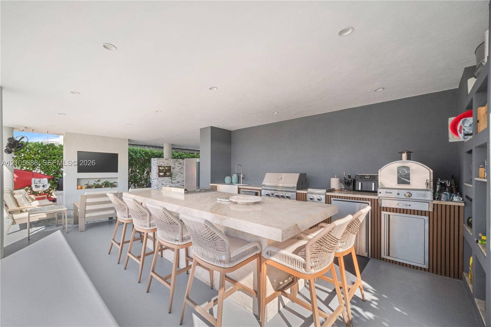 164 W Avenue C, Key Largo, FL 33037 Covered outdoor kitchen featuring a stone-topped island, stainless steel grill, built-in pizza oven, and recessed ceiling lighting