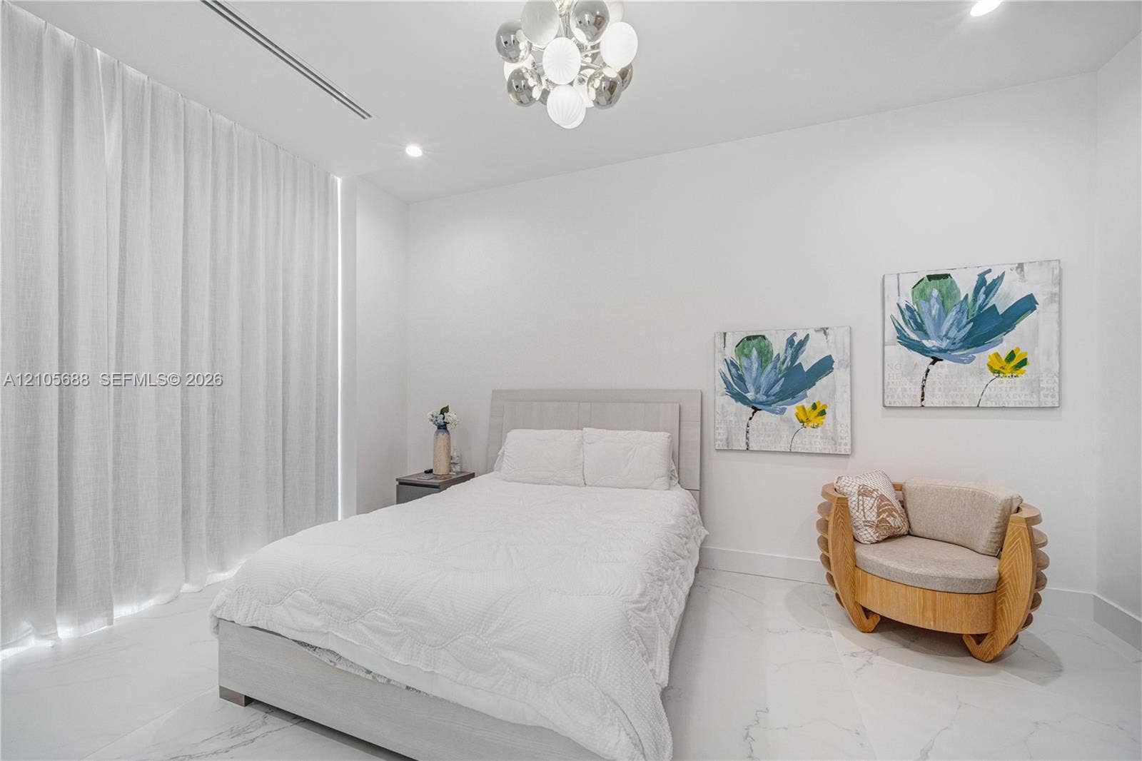 164 W Avenue C, Key Largo, FL 33037 Light-filled room featuring large-format stone-finish flooring, floor-to-ceiling drapery, recessed linear lighting, and a tiered spherical chandelier