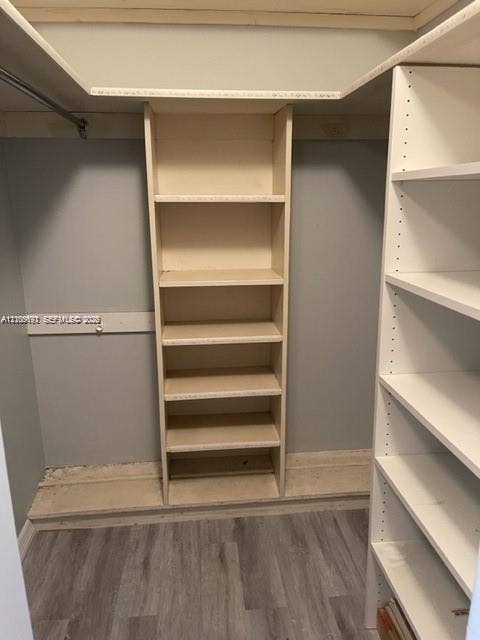 950 Hillcrest Drive, #506, Hollywood, Hollywood, FL 33021 Walk-in closet featuring wood-finish flooring, built-in shelving towers, and metal hanging rods