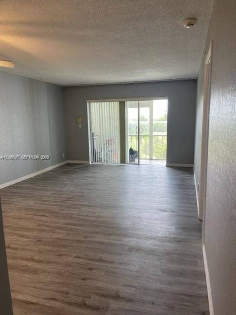 950 Hillcrest Drive, #506, Hollywood, Hollywood, FL 33021 Open-concept interior featuring wood-finish flooring, neutral wall tones, and glass sliding doors leading to an exterior balcony