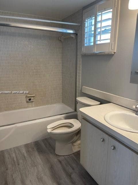 950 Hillcrest Drive, #506, Hollywood, Hollywood, FL 33021 Bathroom featuring wood-finish flooring, a vanity with a solid-surface countertop and integrated sink, a shower-tub combination with tiled surround, and plantation-style shutters