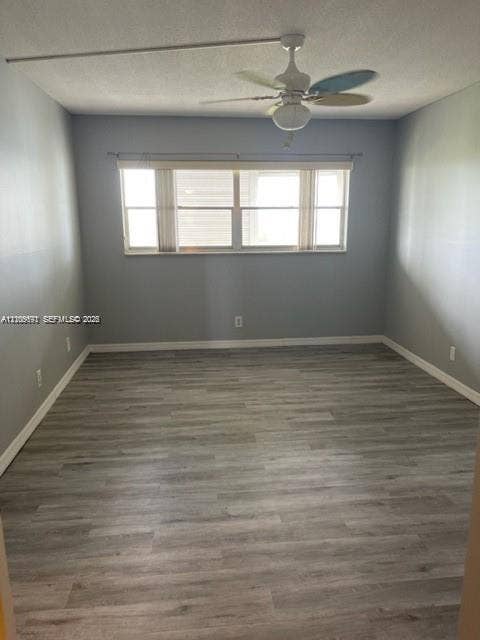 950 Hillcrest Drive, #506, Hollywood, Hollywood, FL 33021 Room featuring neutral wall paint, wood-finish flooring, a multi-pane horizontal window, and a ceiling-mounted light fixture with an integrated fan