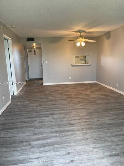 950 Hillcrest Drive, #506, Hollywood, Hollywood, FL 33021 Open-concept interior featuring wood-finish flooring, a neutral color palette, ceiling fan with light fixture, and a pass-through opening