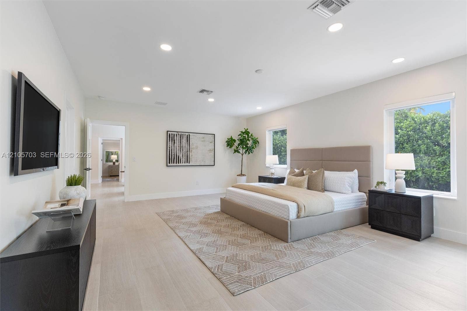190 NW 102nd Street, Miami Shores, FL 33150 Spacious room featuring neutral interior walls, light-toned wood-finish flooring, recessed ceiling lighting, and multiple windows