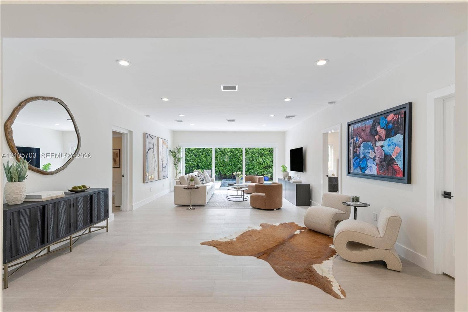 190 NW 102nd Street, Miami Shores, FL 33150 Open-concept interior featuring light-toned flooring, recessed lighting, and expansive sliding glass doors