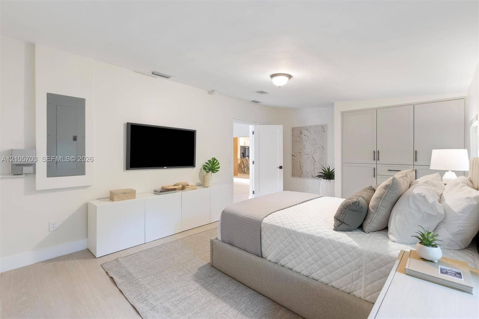 190 NW 102nd Street, Miami Shores, FL 33150 Custom built-in white cabinetry, light-toned wood-finish flooring, integrated wall-mounted electrical panel, and recessed ceiling lighting