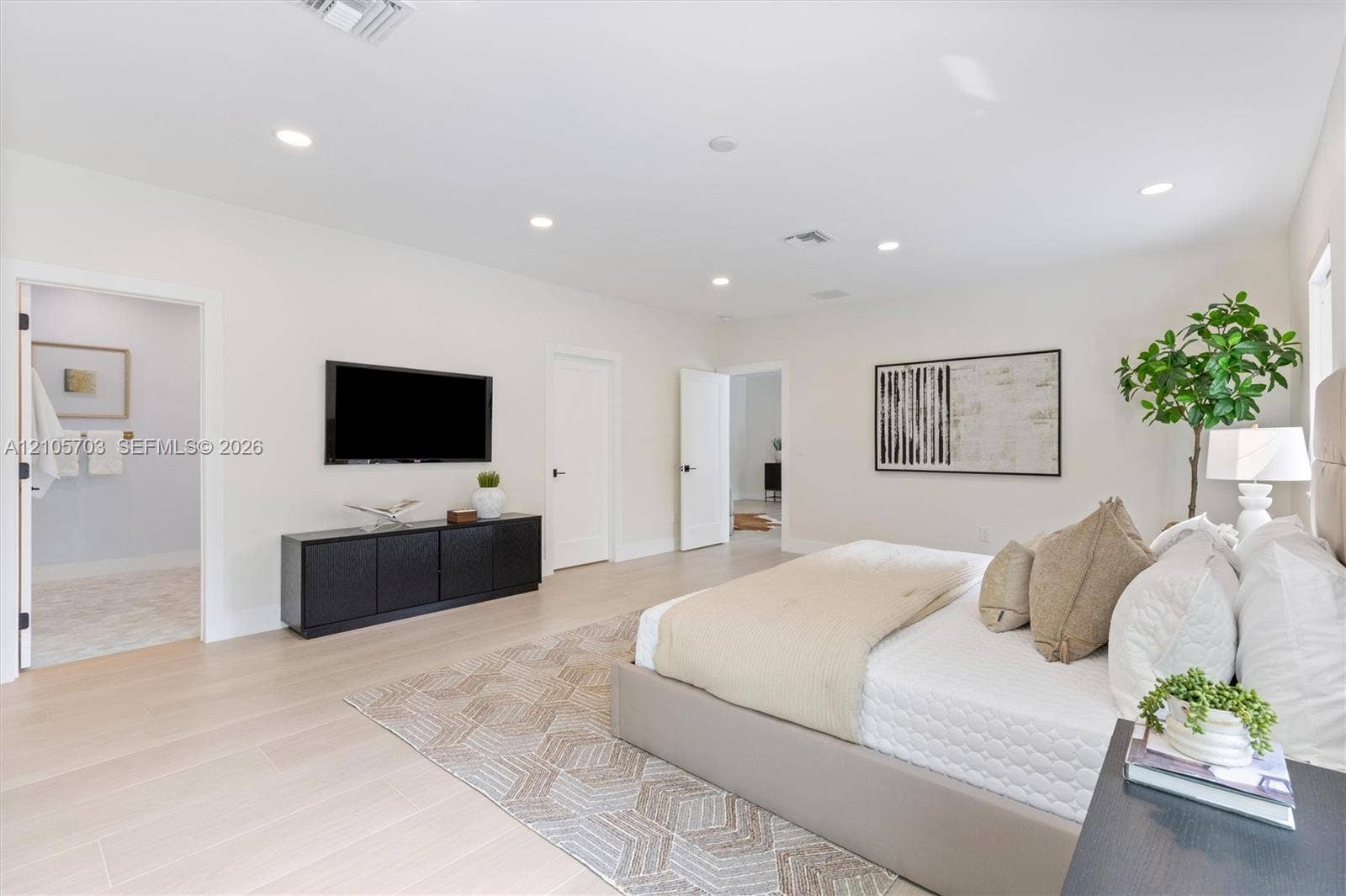 190 NW 102nd Street, Miami Shores, FL 33150 Spacious room featuring neutral wall tones, wood-finish flooring, and recessed ceiling lighting
