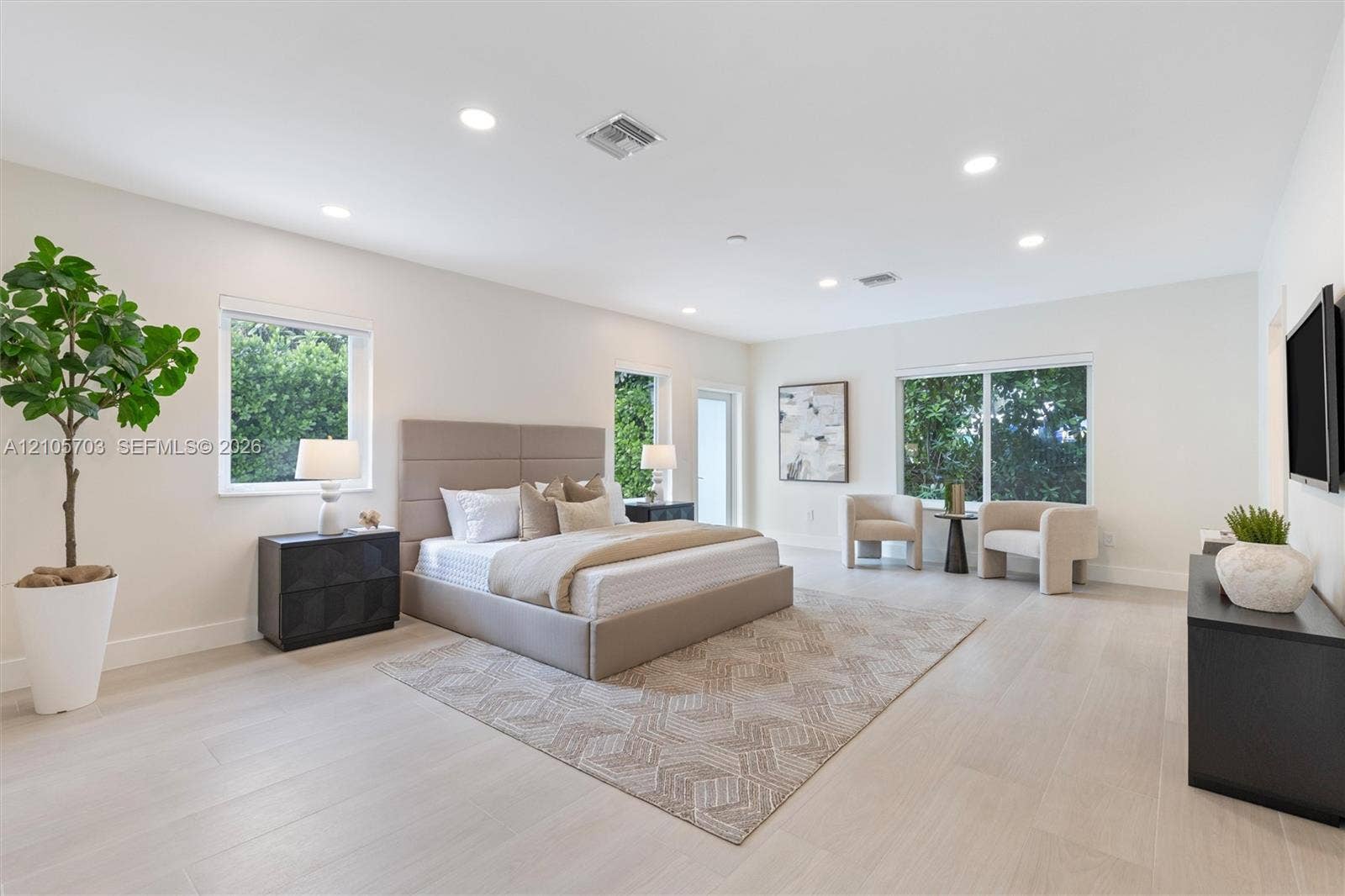 190 NW 102nd Street, Miami Shores, FL 33150 Spacious room featuring wood-finish flooring, recessed lighting, and multiple windows providing natural light