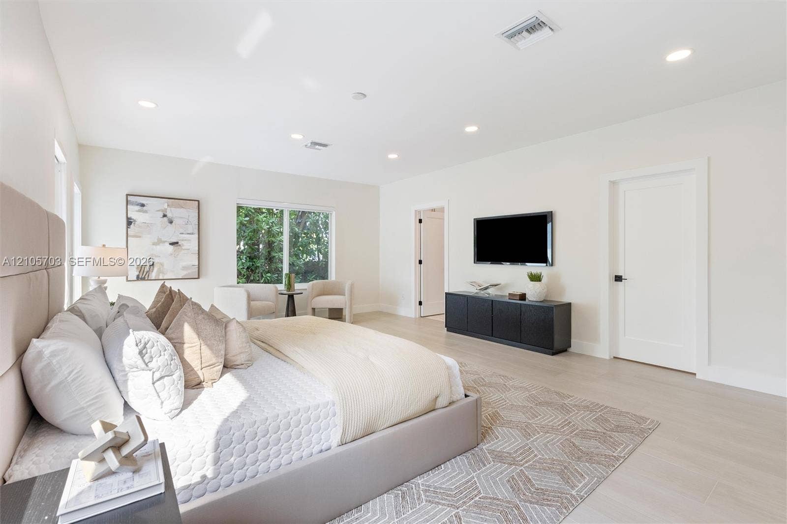 190 NW 102nd Street, Miami Shores, FL 33150 Neutral color palette featuring light-toned wood-finish flooring, recessed ceiling lighting, and solid-core interior doors with matte black hardware