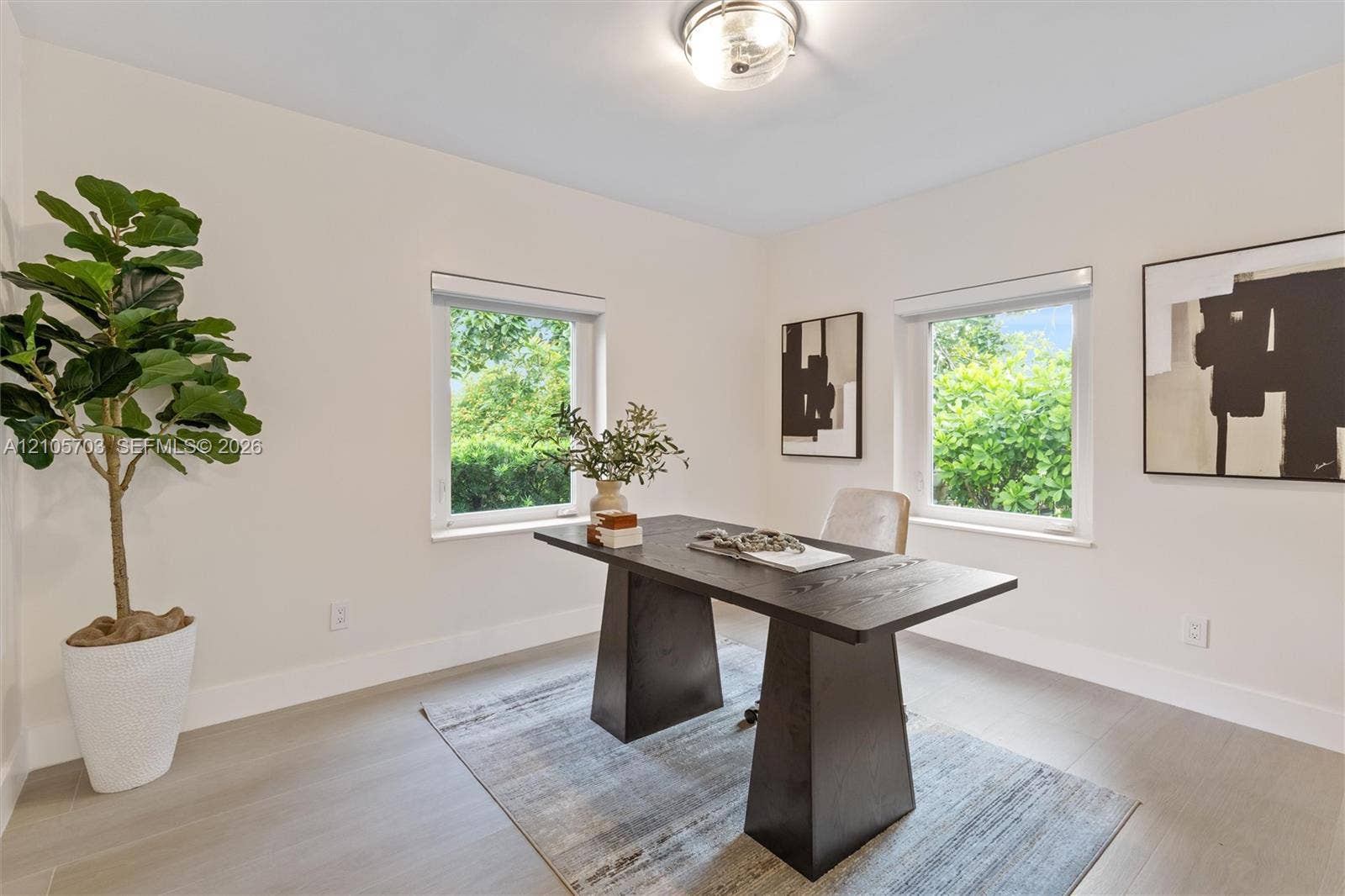 190 NW 102nd Street, Miami Shores, FL 33150 Neutral-toned interior space featuring light-colored flooring, two dual-pane windows, and a flush-mount ceiling fixture