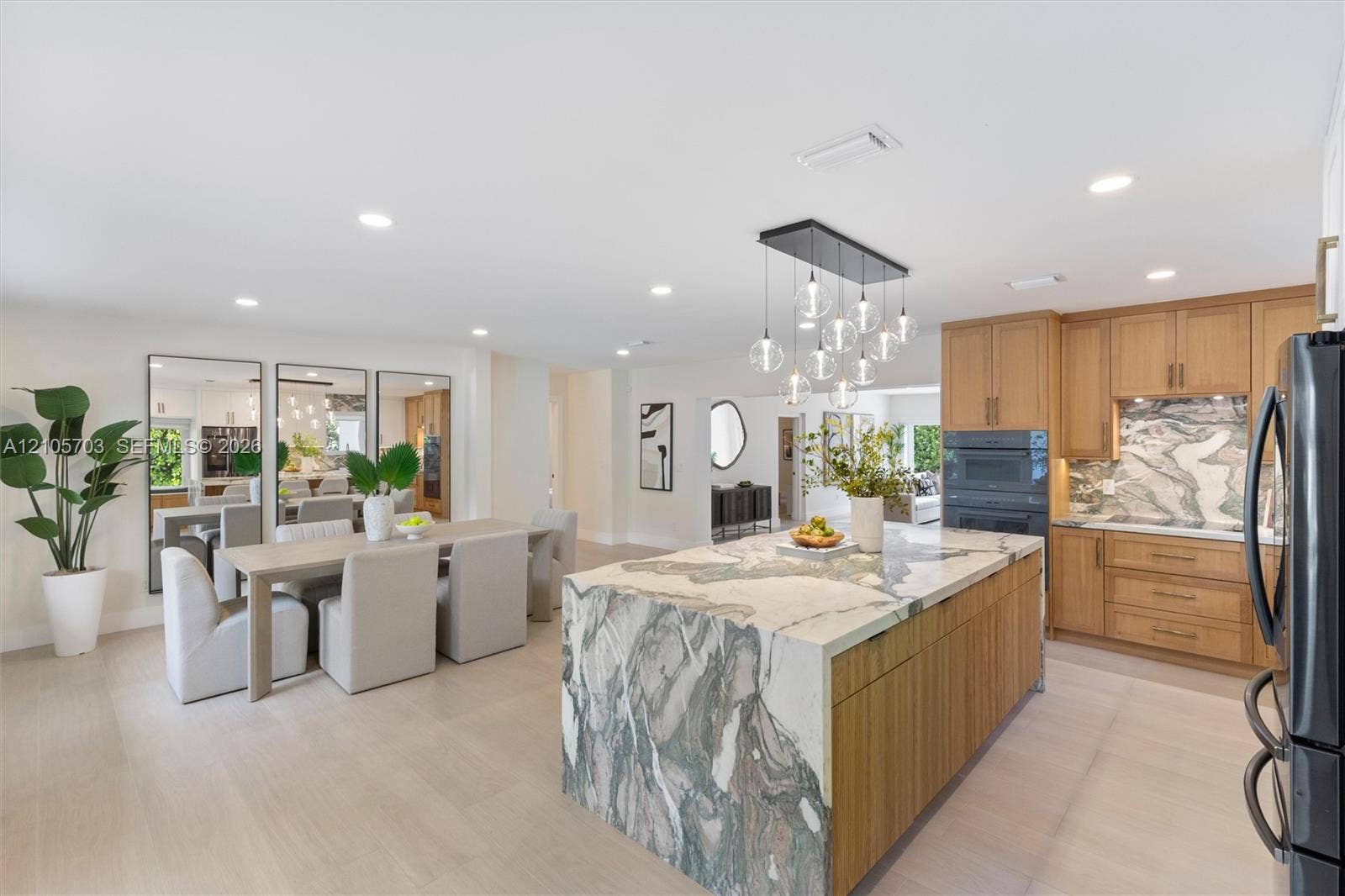 190 NW 102nd Street, Miami Shores, FL 33150 Kitchen featuring a stone-topped waterfall island, custom wood-finish cabinetry, built-in wall oven, recessed lighting, and contemporary multi-pendant light fixture