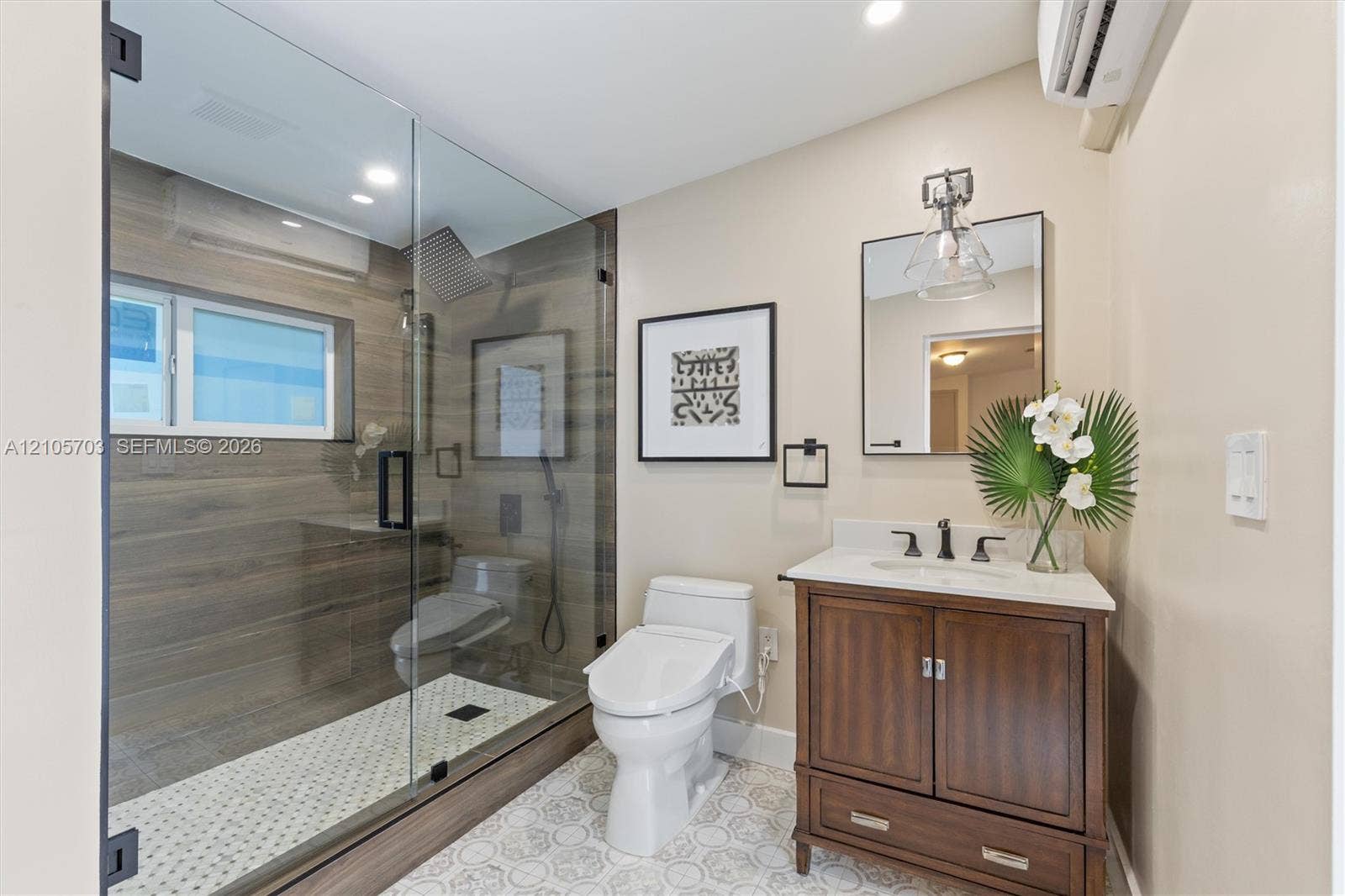 190 NW 102nd Street, Miami Shores, FL 33150 Walk-in shower with wood-finish tile surround, frameless glass enclosure, and rainfall showerhead